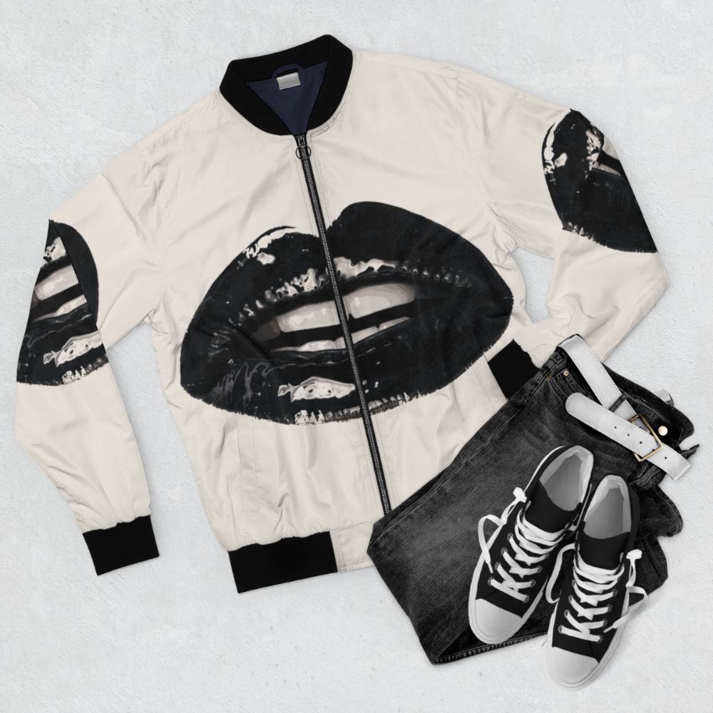 Black bomber jacket with realistic lips and teeth design, featuring a gothic, vampire-inspired style. - Flat lay