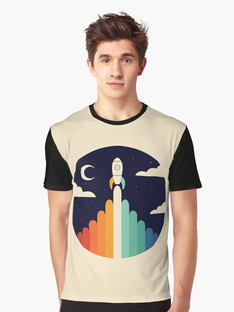 A graphic t-shirt featuring a rocket ship soaring through the sky, with a rainbow and clouds in the background, representing dreams and space exploration. - Men