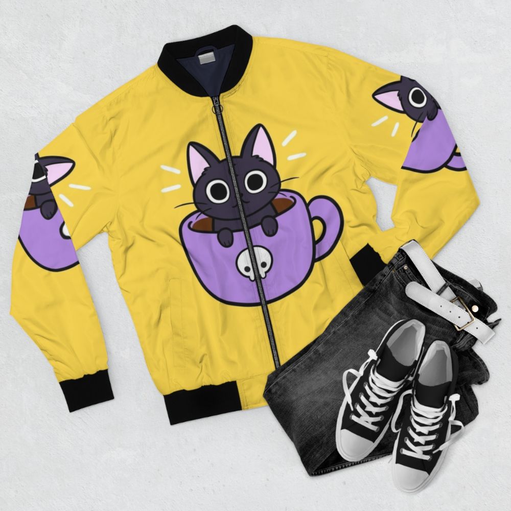 A black and purple bomber jacket with a cute, smiling cat print and coffee/drink elements. - Flat lay