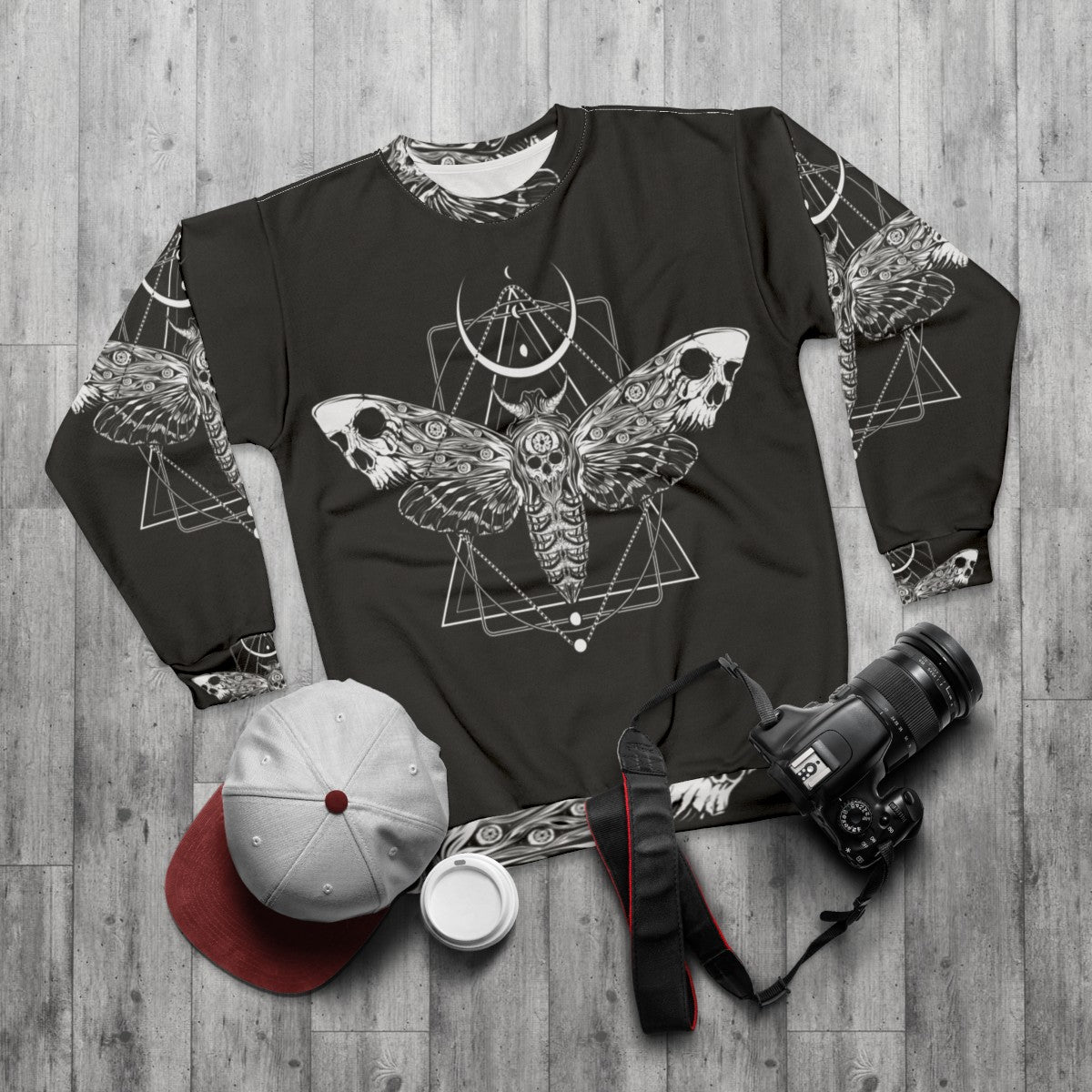 Surreal death moth graphic on a black sweatshirt - flat lay