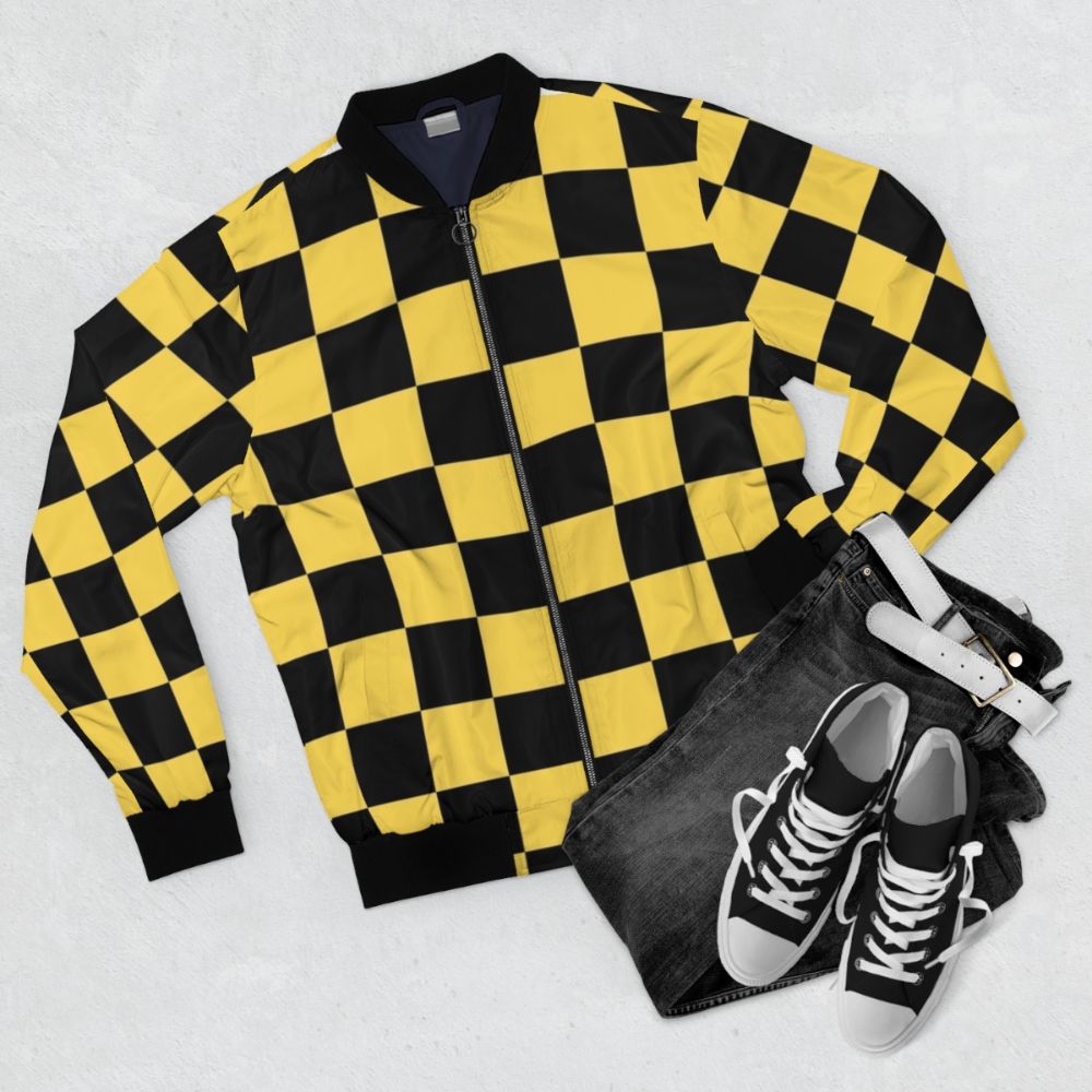 A black and yellow checkered bomber jacket with a geometric, patterned design. - Flat lay