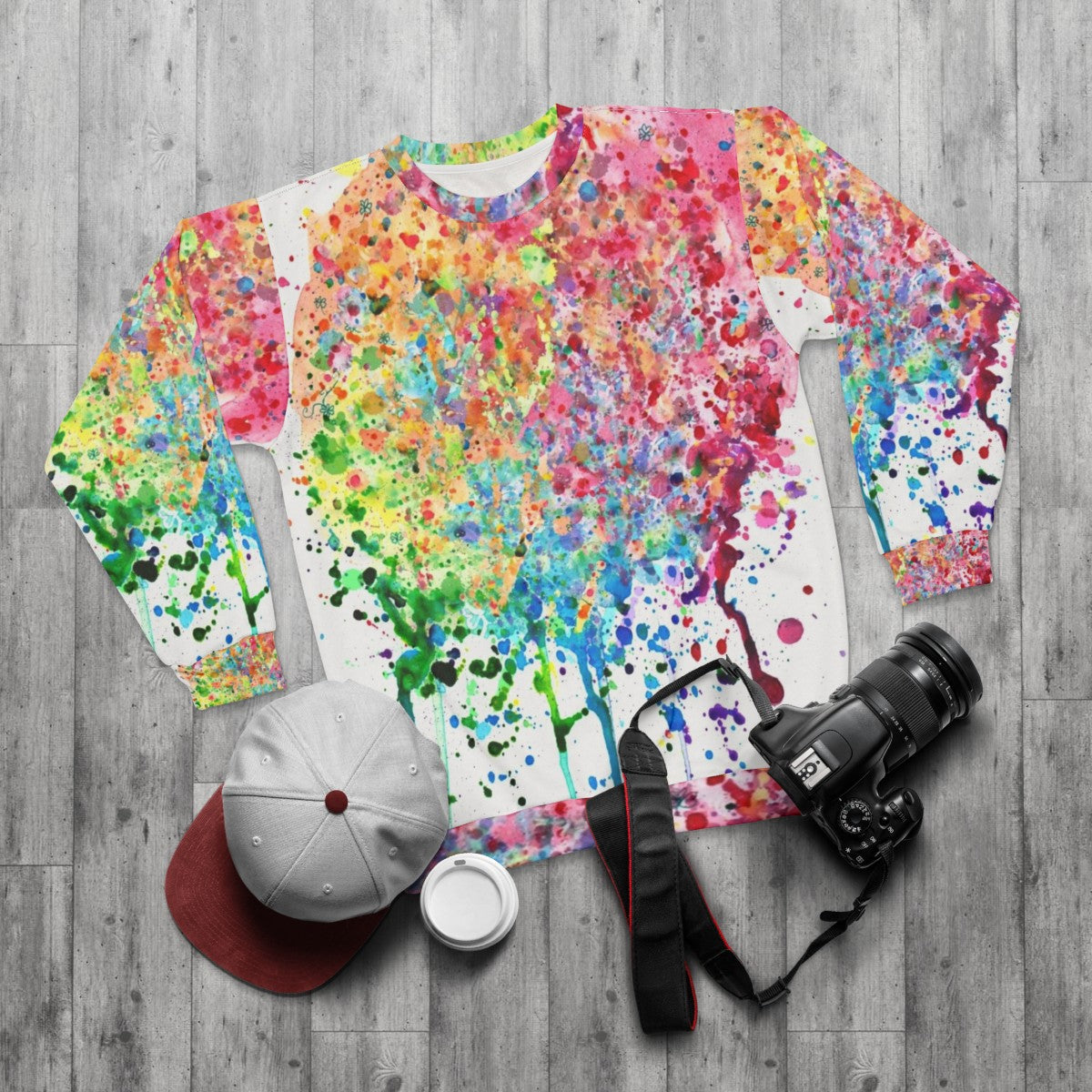 Colorful rainbow paint splatter drip design on a sweatshirt - flat lay