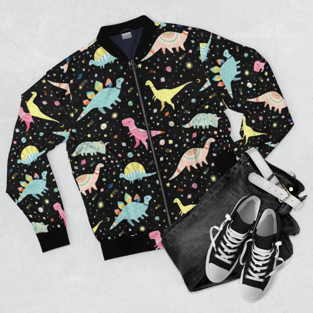 A colorful dinosaur-patterned bomber jacket for kids, featuring T-rex, Apatosaurus, Stegosaurus, and other prehistoric creatures. - Flat lay