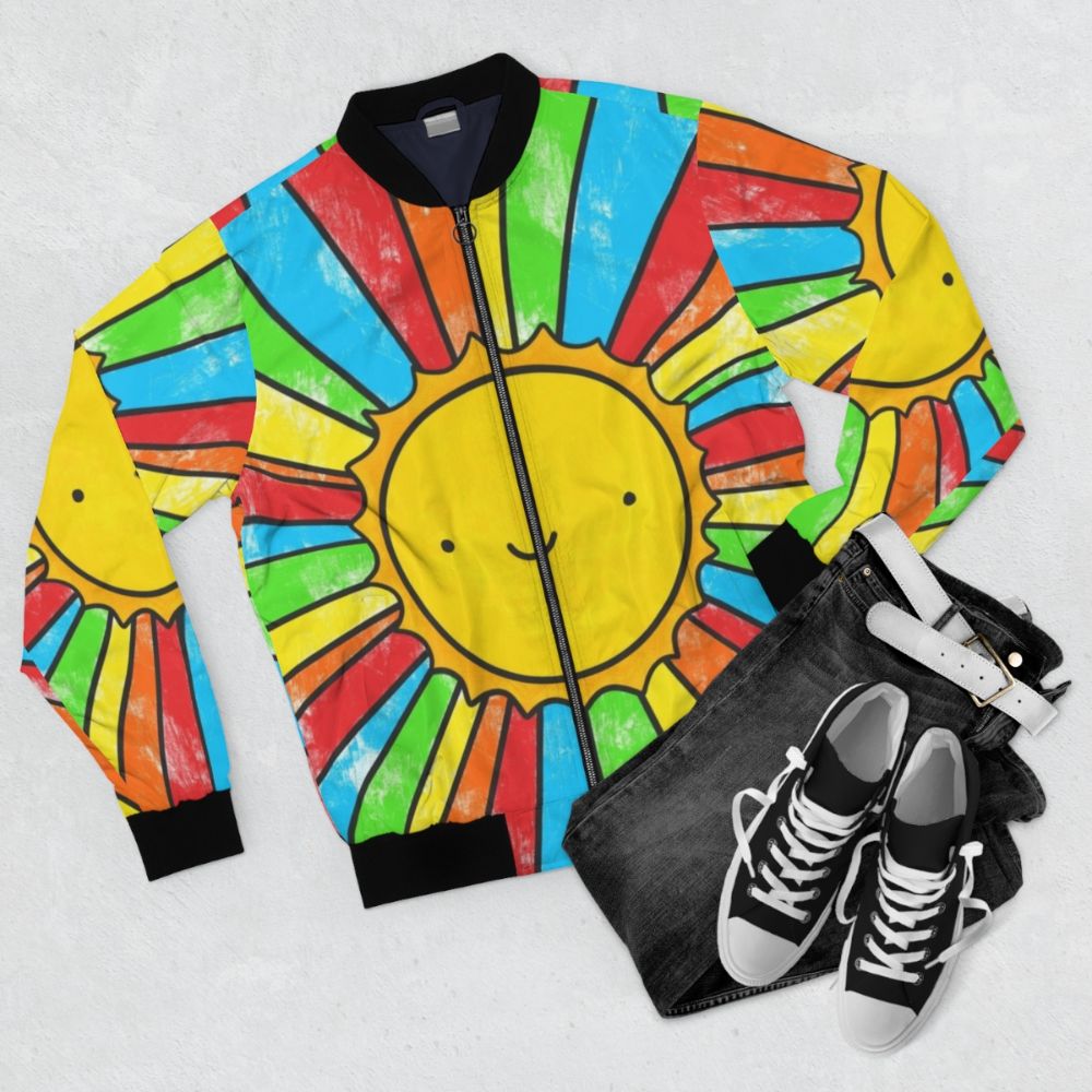 A colorful bomber jacket with a radiant sunshine, rainbows, and a positive quote to spread happiness and positivity. - Flat lay