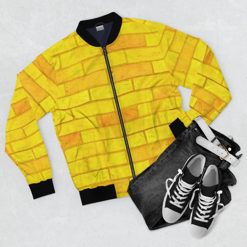 Retro yellow bomber jacket with graphic design elements inspired by The Wizard of Oz - Flat lay