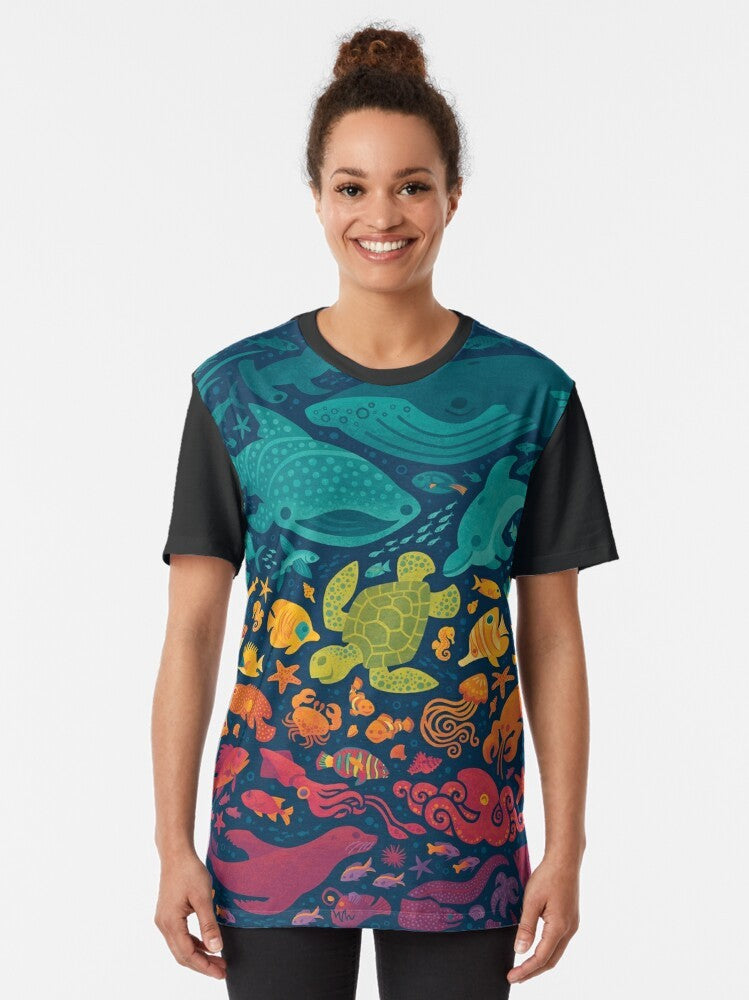 Colorful graphic t-shirt featuring a vibrant aquatic spectrum design with various sea creatures and marine life. - Women