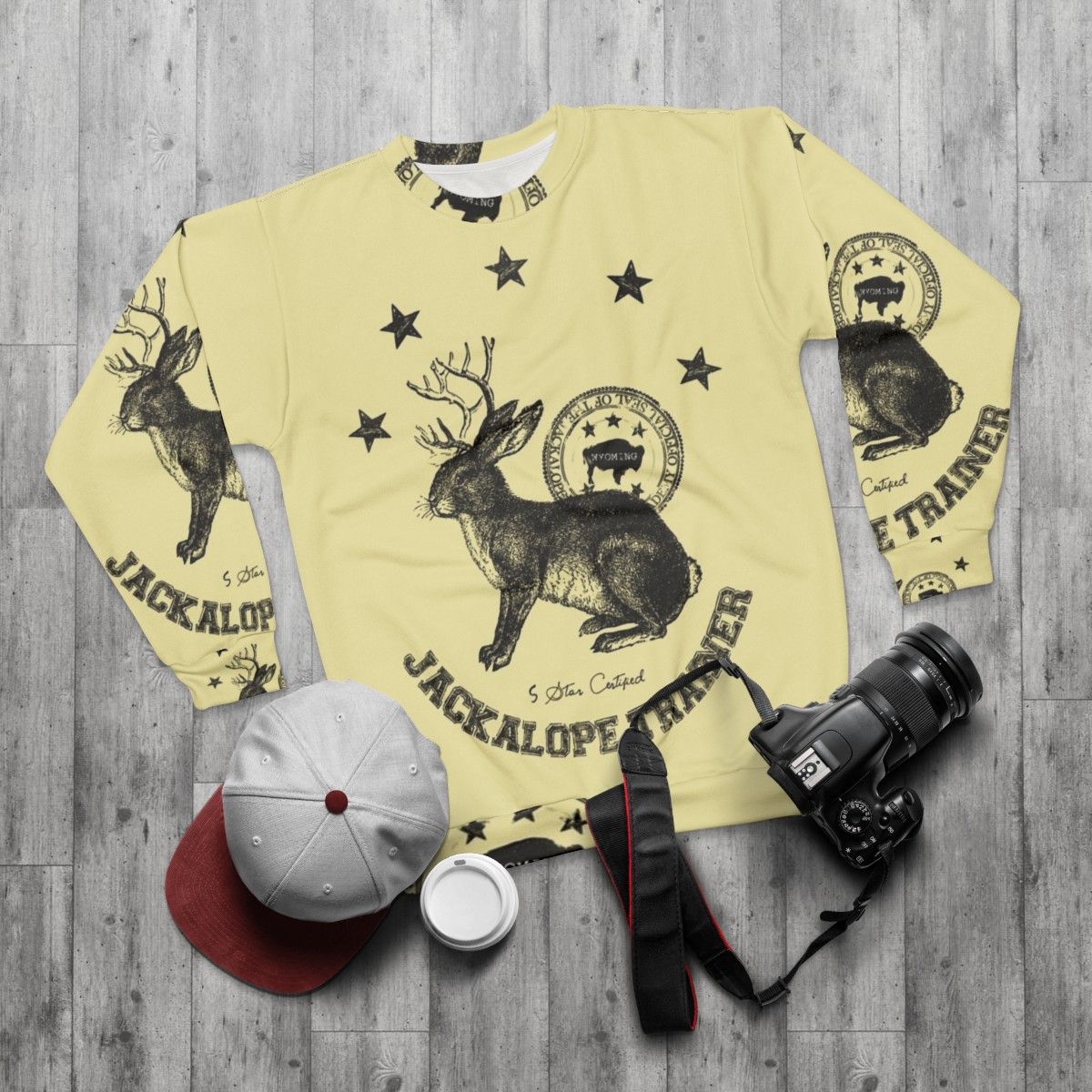 Beige sweatshirt with jackalope graphic, mythical animal trainer design - flat lay