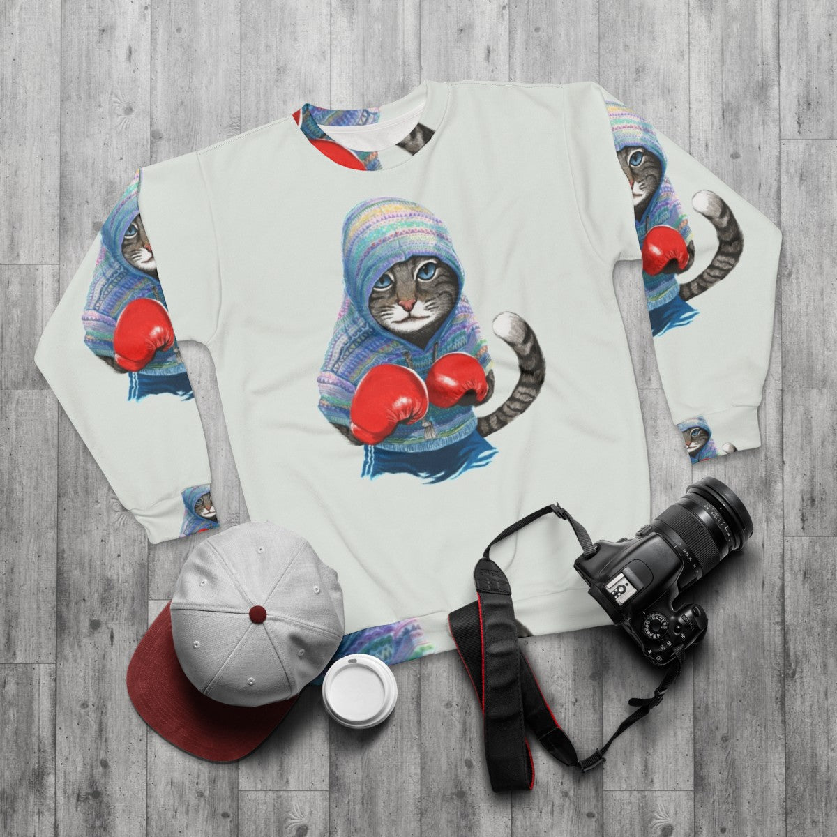 Boxing cat silhouette graphic on blue sweatshirt - flat lay