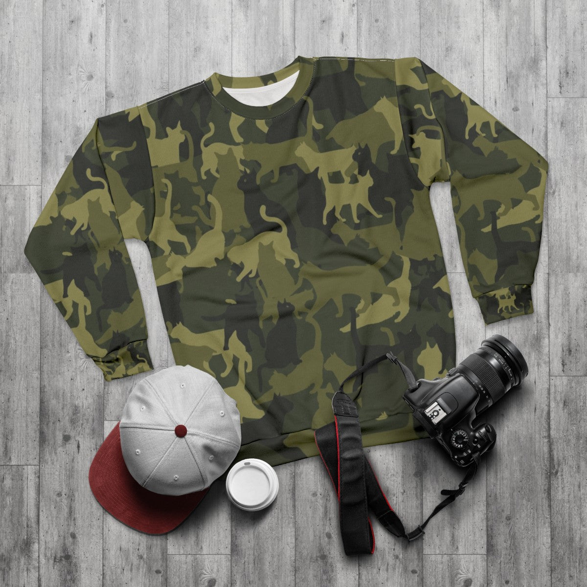 Cute cat wearing camouflage sweatshirt - flat lay