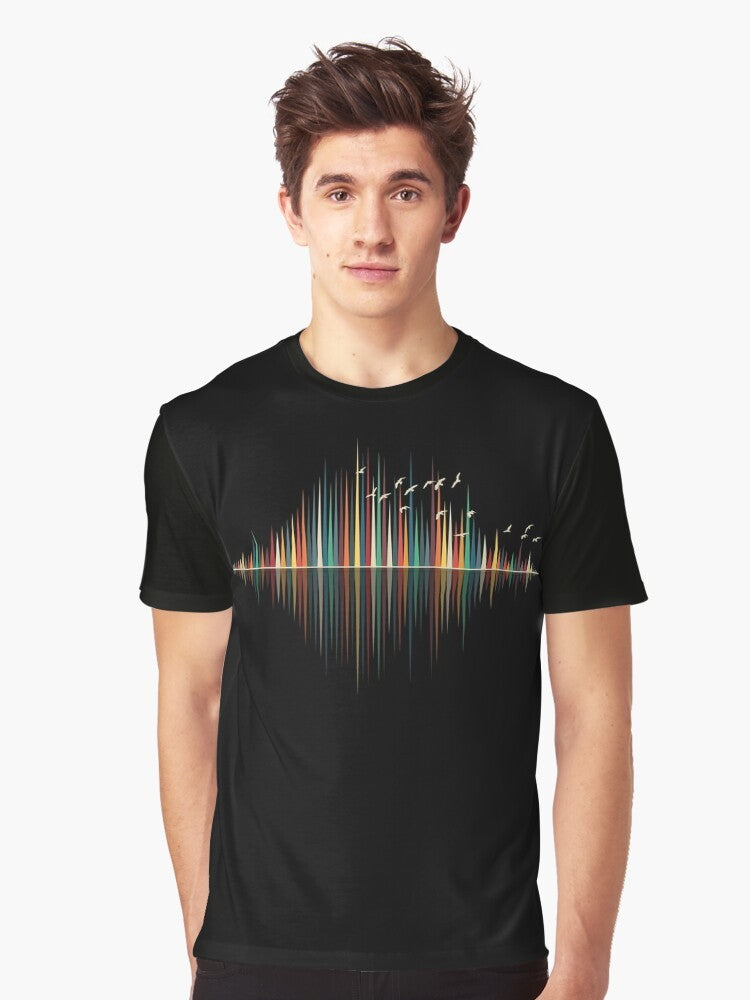 A minimalist graphic t-shirt design featuring a colorful sound wave silhouette with birds flying against a sunset background. - Men