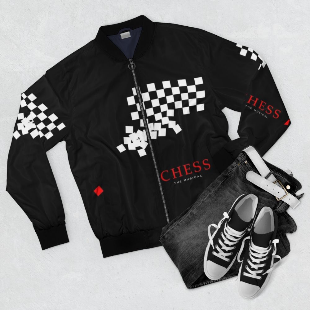 A bomber jacket featuring the logo and imagery from the classic Broadway musical "Chess" - Flat lay