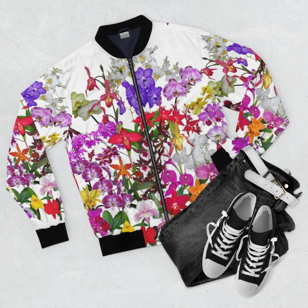 Vibrant bomber jacket featuring a digital photography design of colorful orchid flowers in various shades of red, pink, yellow, and more. - Flat lay