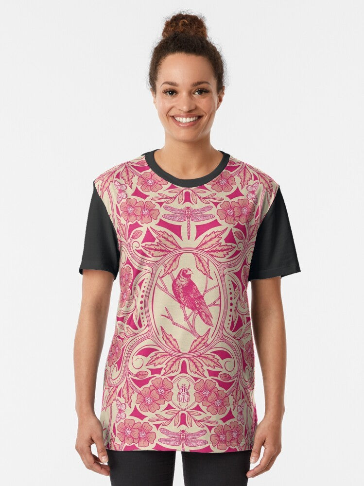 Detailed floral graphic featuring a crow and dragonfly in vibrant hot pink, red, and cream colors on a graphic t-shirt. - Women