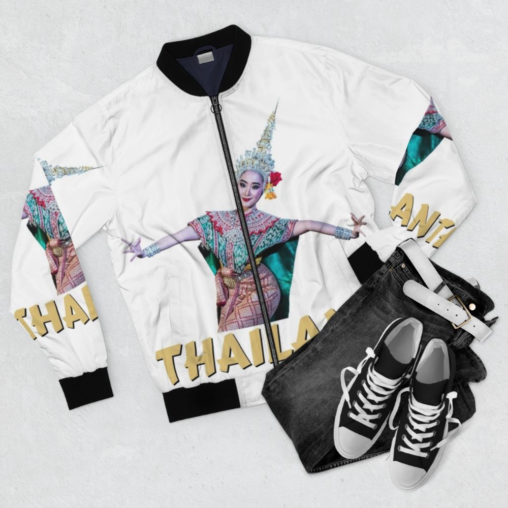 A bomber jacket featuring a traditional Thai dance design with graceful dancers and cultural elements. - Flat lay