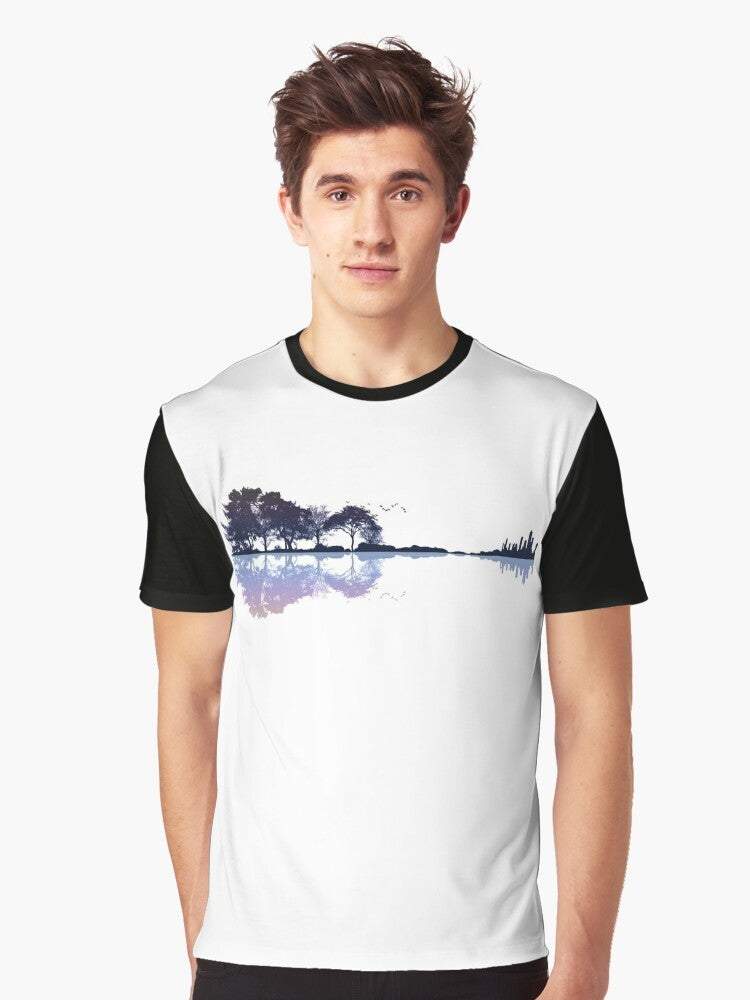 A nature-inspired graphic t-shirt featuring a guitar silhouette against a landscape with trees, water, and a cityscape. - Men