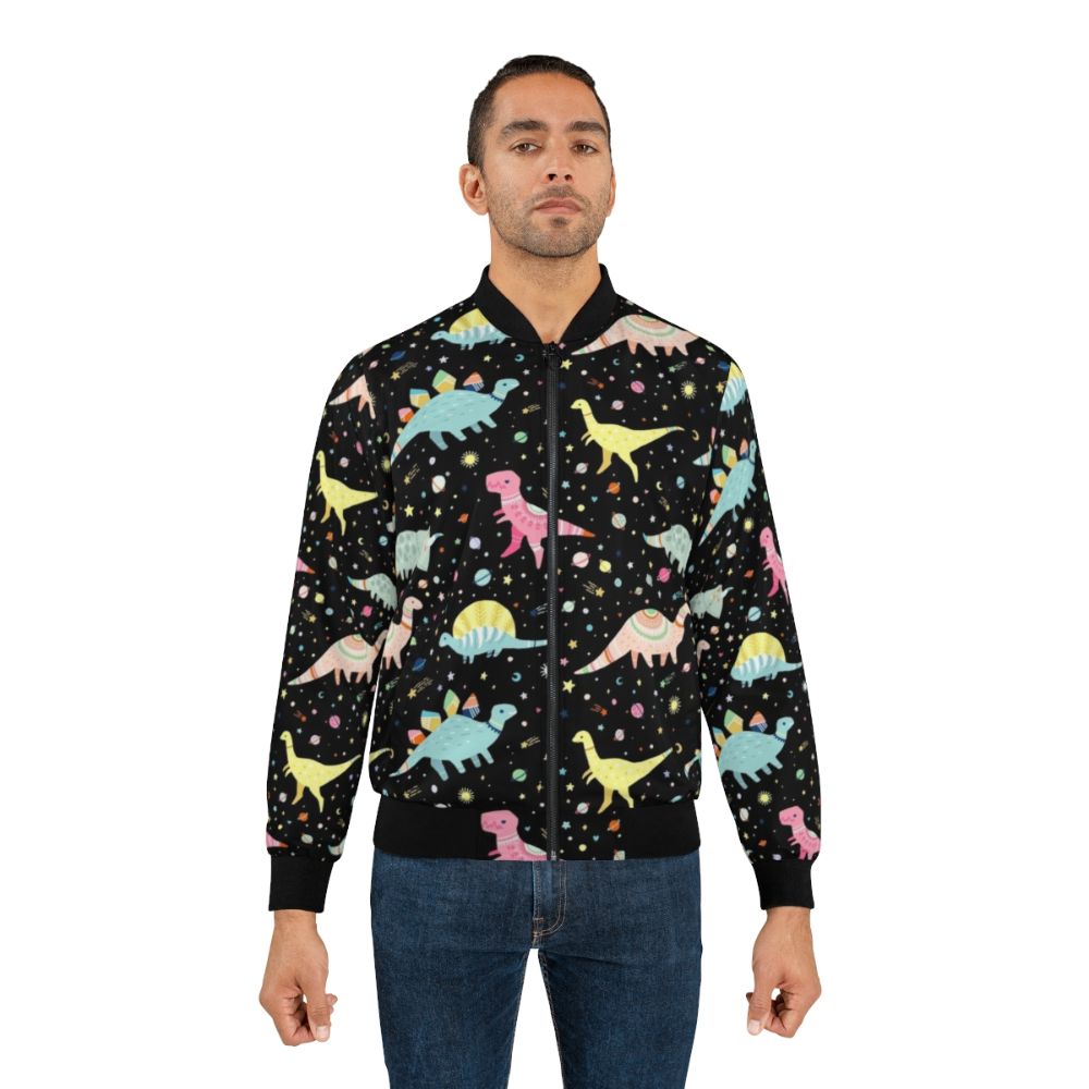 A colorful dinosaur-patterned bomber jacket for kids, featuring T-rex, Apatosaurus, Stegosaurus, and other prehistoric creatures. - Lifestyle