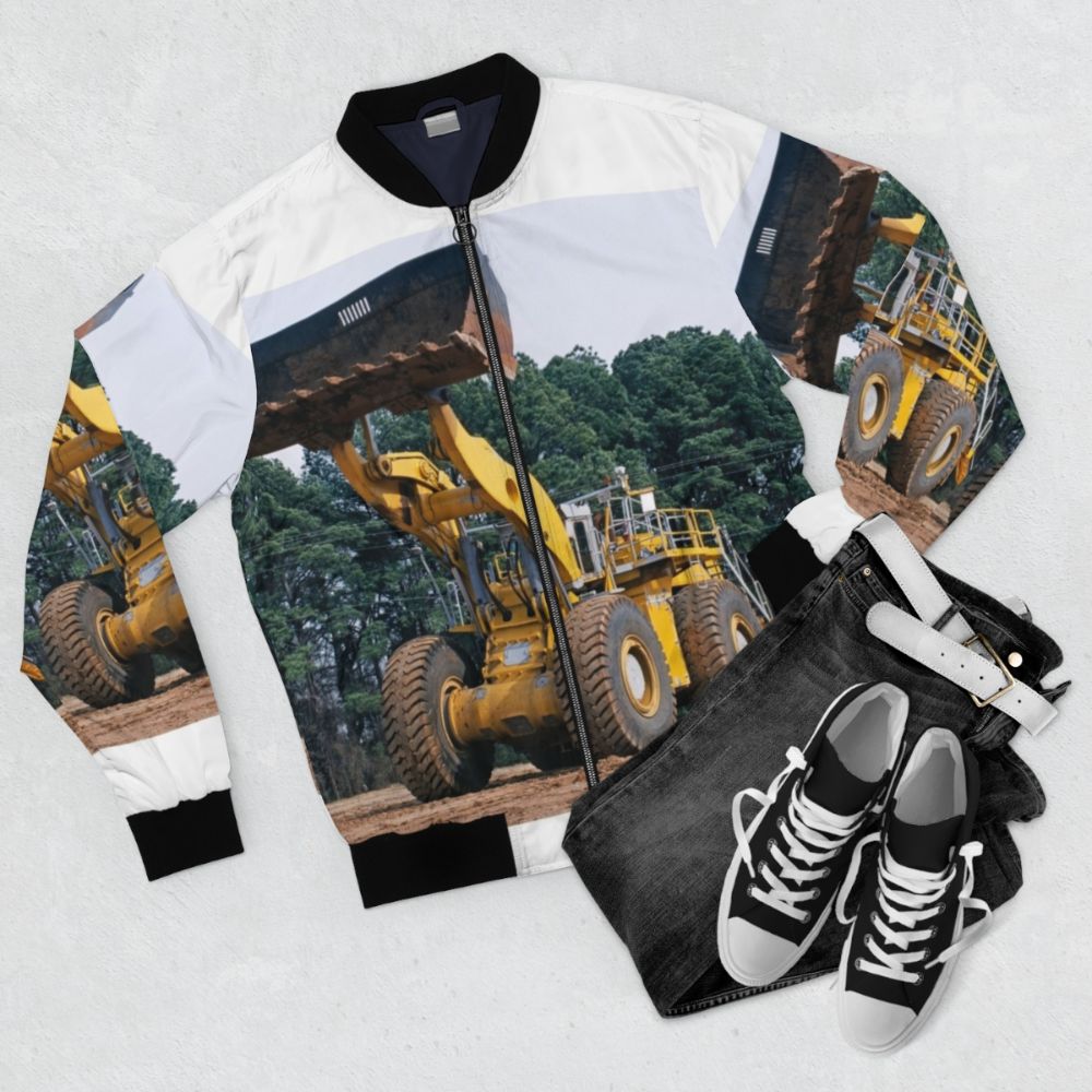 A bomber jacket with wheel loader equipment graphic design, showcasing industrial technology and machinery. - Flat lay