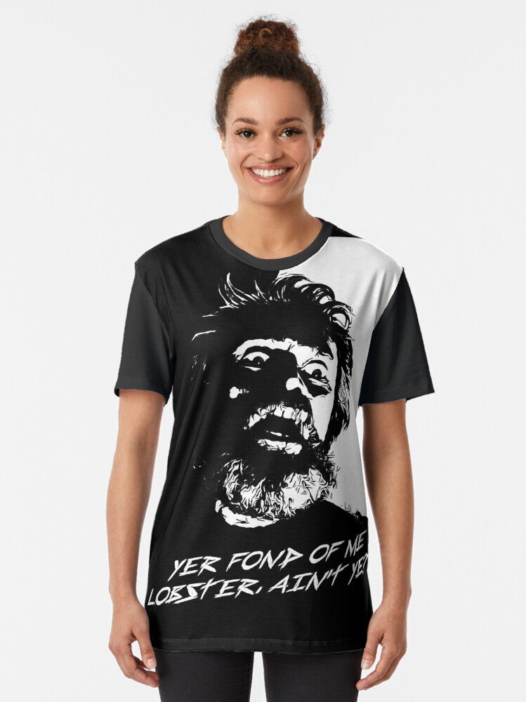 A graphic t-shirt featuring a lobster in a lighthouse, with references to the film "The Lighthouse" and its stars Willem Dafoe and Robert Pattinson. - Women