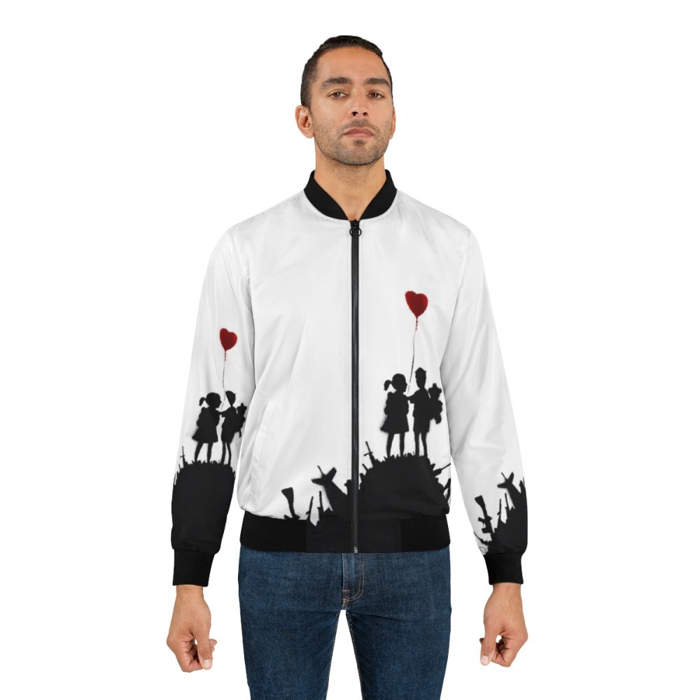 Banksy-style graffiti design with children and heart-shaped balloon against a backdrop of weapons on a bomber jacket - Lifestyle