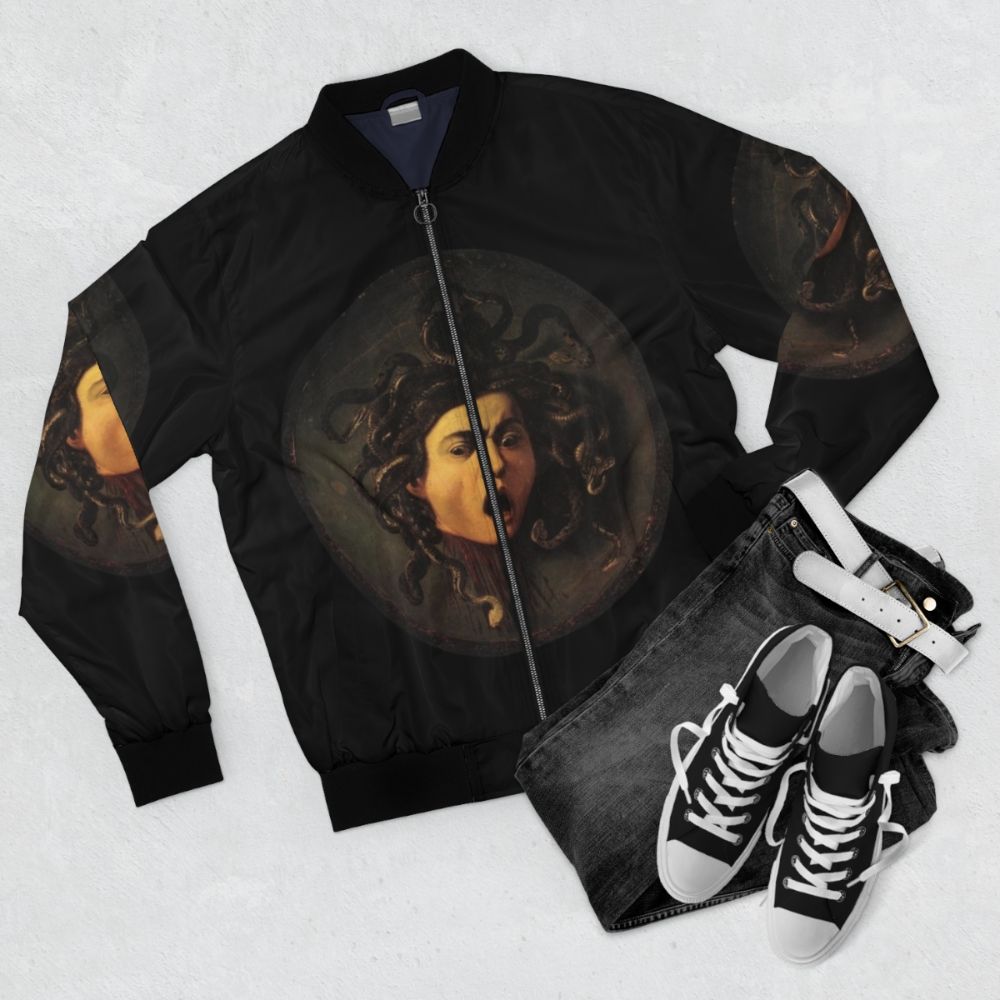 A bomber jacket featuring the iconic image of Medusa, the gorgon from Greek mythology, in a Caravaggio-style realist painting. - Flat lay