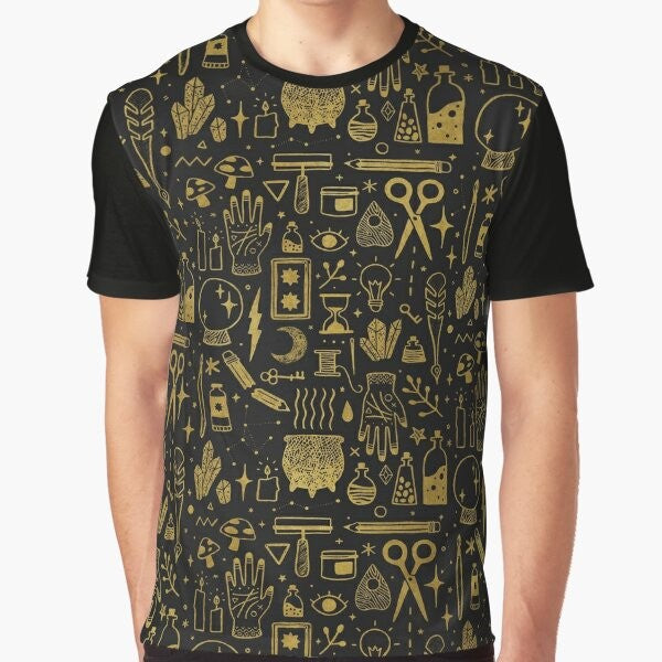 A gold and black graphic t-shirt featuring the words "Make Magic" with occult and witchy elements like a cauldron, mushrooms, and tarot cards.