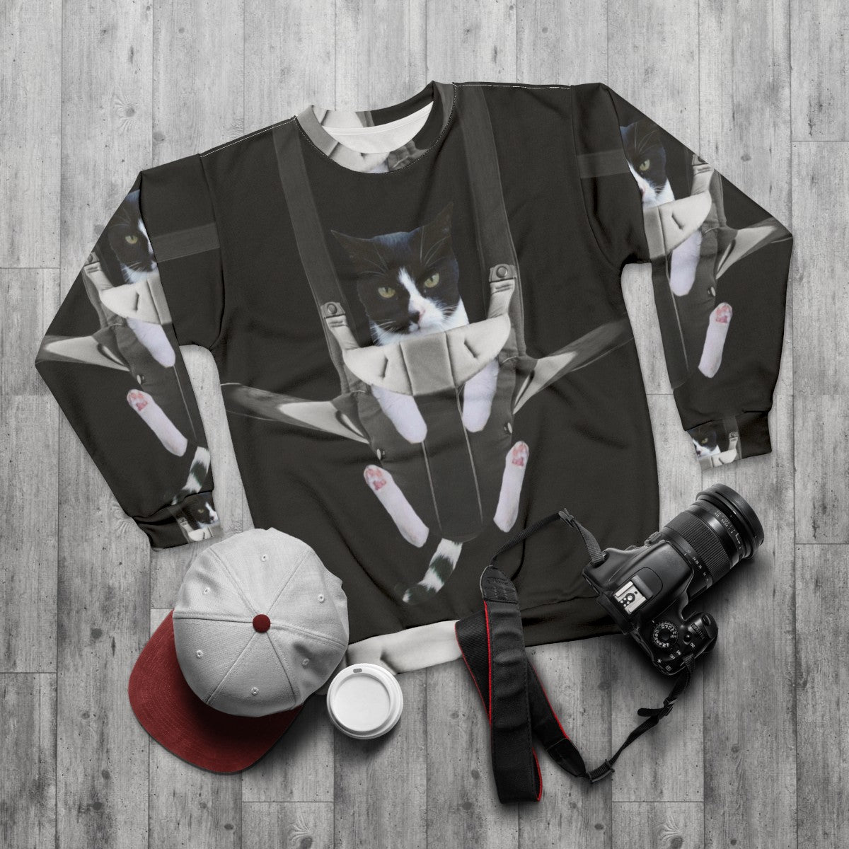 A woman wearing a sweatshirt with a cat in a baby carrier print - flat lay