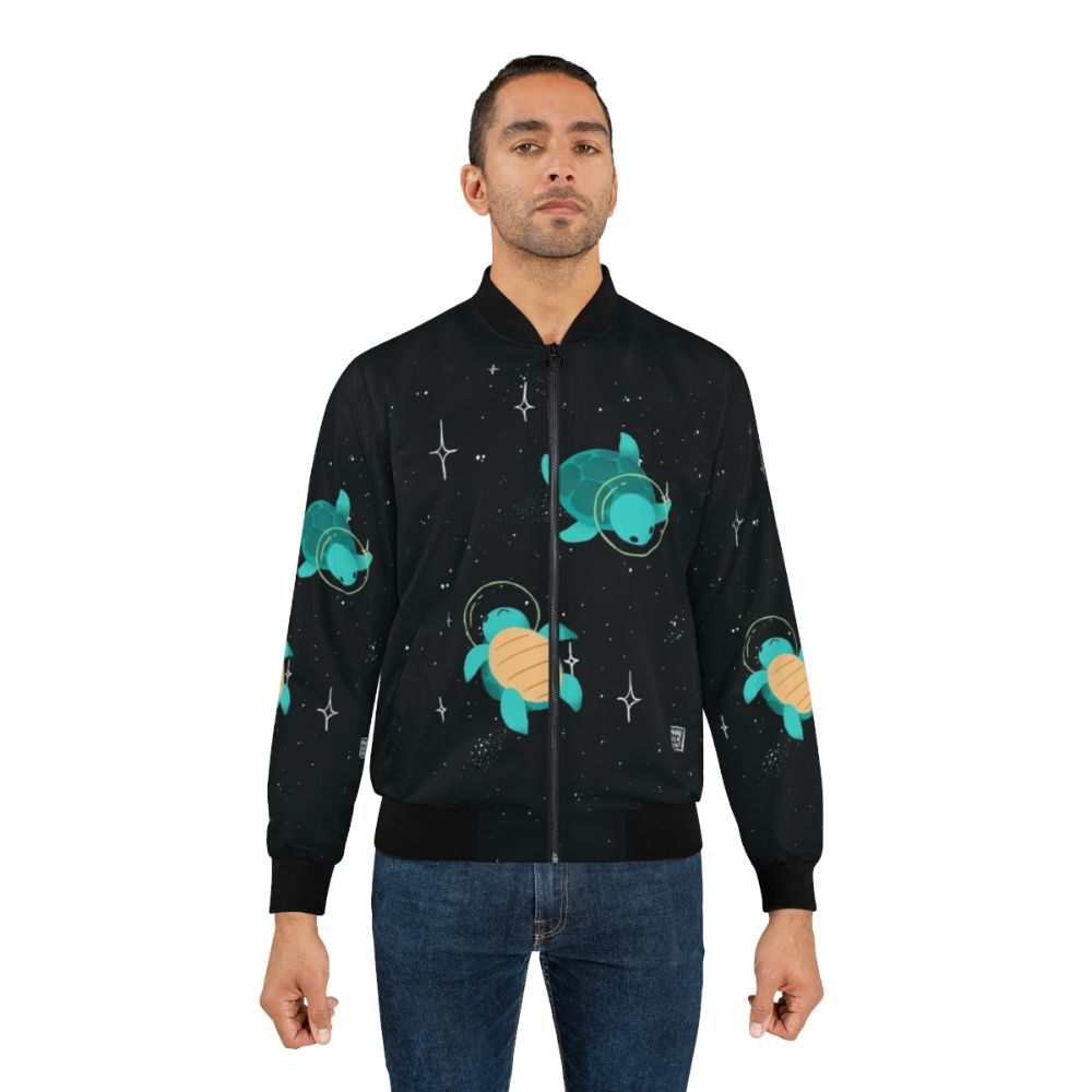 Space turtle bomber jacket with a cute, green turtle design against a starry, galaxy background. - Lifestyle