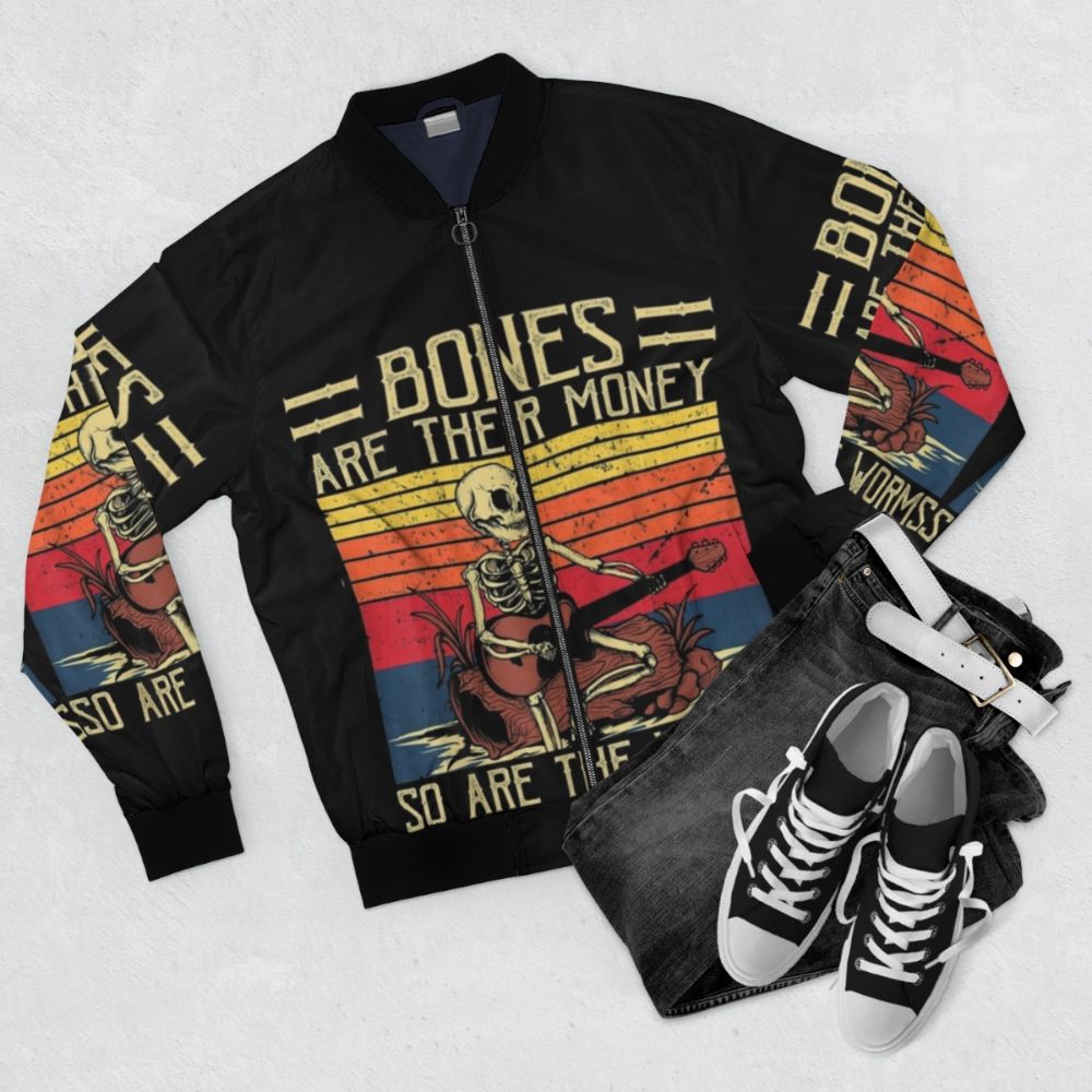 Retro vintage bomber jacket with a skeleton playing a guitar design, inspired by the comedy series "I Think You Should Leave with Tim Robinson". - Flat lay