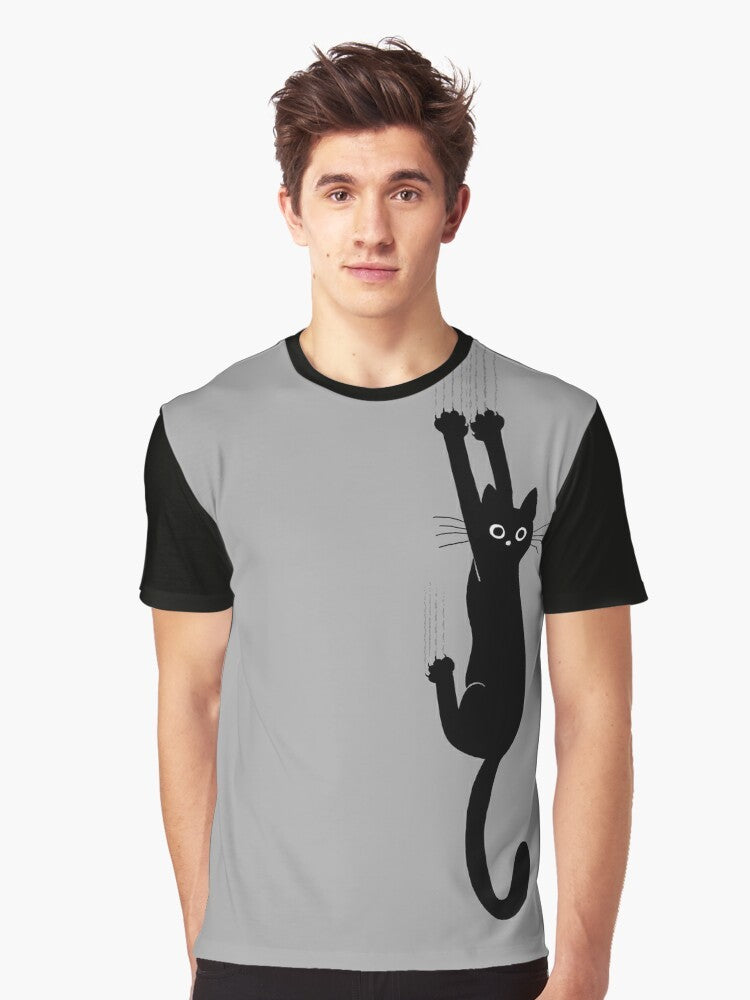 Graphic t-shirt featuring a black cat holding on with its claws and an expression of perseverance and humor - Men