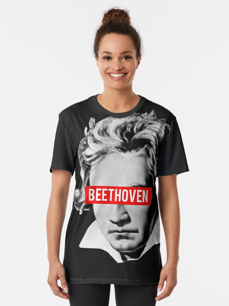 A graphic t-shirt featuring a halftone image of Beethoven, the famous classical music composer, surrounded by musical instruments like violin, viola, cello, and bass. - Women