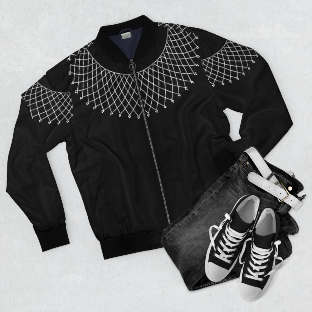 A bomber jacket featuring a beaded collar with the RBG (Ruth Bader Ginsburg) design, representing the feminist and liberal ideals of the Supreme Court justice. - Flat lay