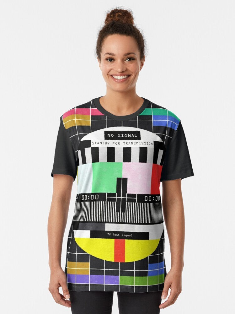 Graphic t-shirt design featuring a retro, glitchy "standby for transmission" message with vintage television and digital art elements. - Women