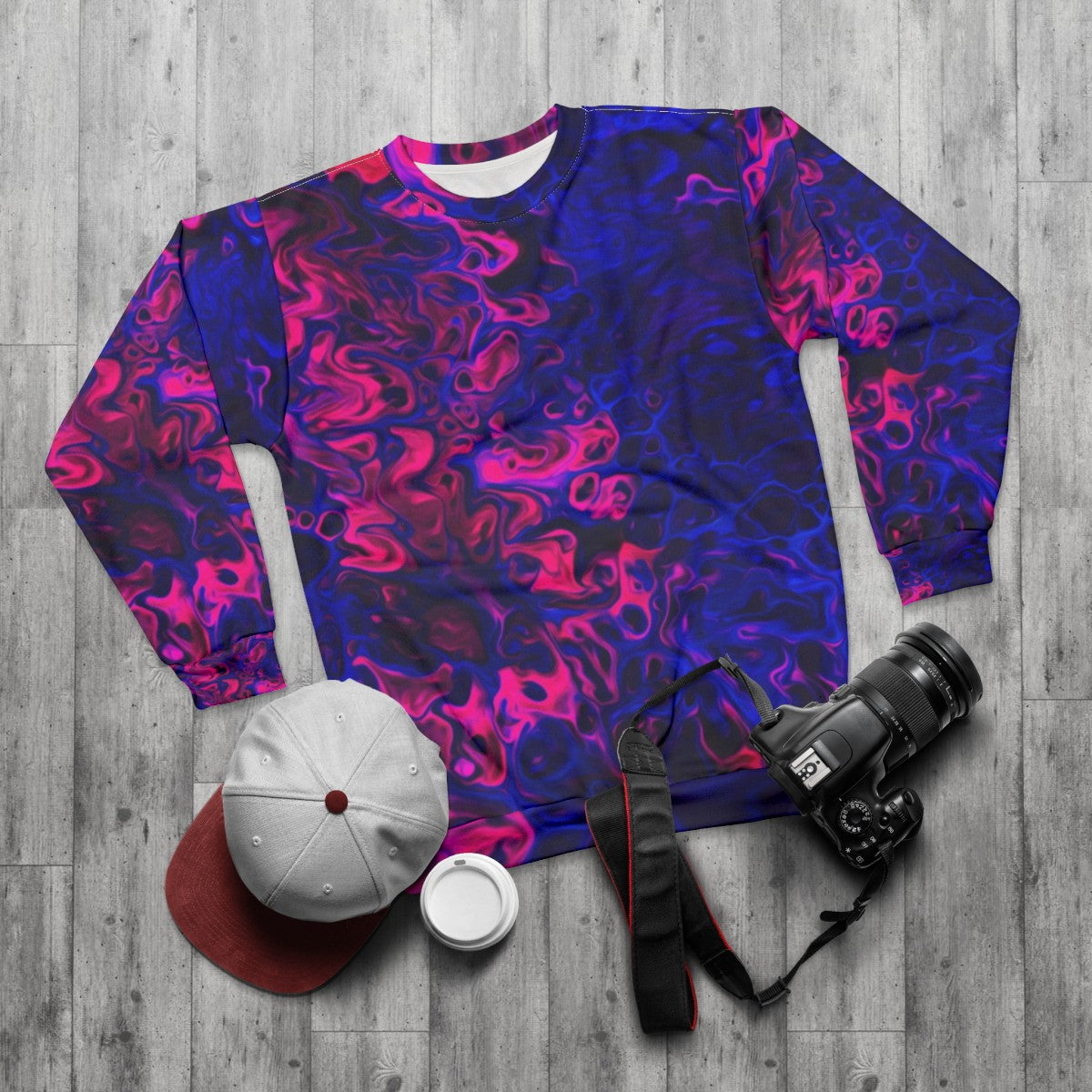 Blacklight poured acrylic sweatshirt with vibrant, energetic abstract pattern - flat lay